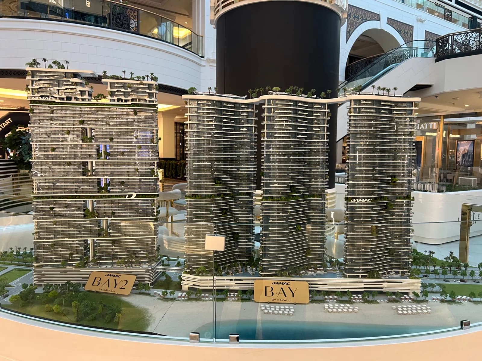 Overview of the DAMAC BAY and BAY 2 by Cavalli architectural model behind a clear display screen.