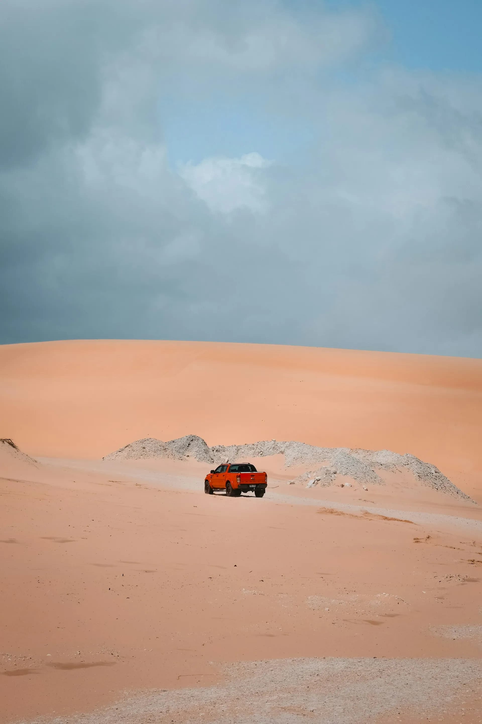 Off-road truck driving through desert dunes